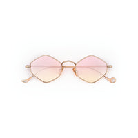 Lunettes losange dorées à verres dégradés roses sur fond blanc